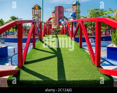 Bridge covered with artificial grass leading to a children's playground, in Children's World Park, Bucharest. Stock Photo
