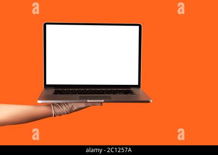 Profile side view closeup of human hand in white surgical gloves holding computer laptop and showing empty copy space on monitor screen. indoor, studi Stock Photo