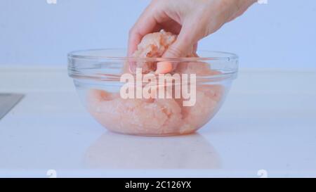 Girl is preparing minced meat. A female hand mixes the minced chicken and pork. Meat dishes Stock Photo