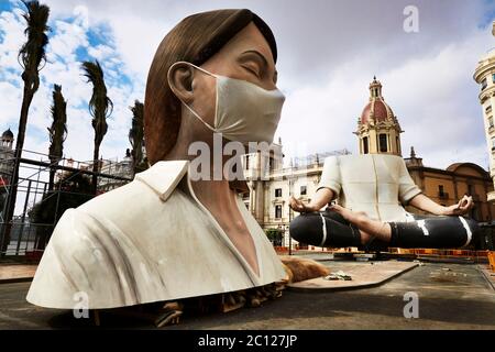 Incomplete sculpture for the cancelled 2020 Las Fallas festival in Valencia wearing an improvised mask to protected her against Covid 19 virus, Spain. Stock Photo