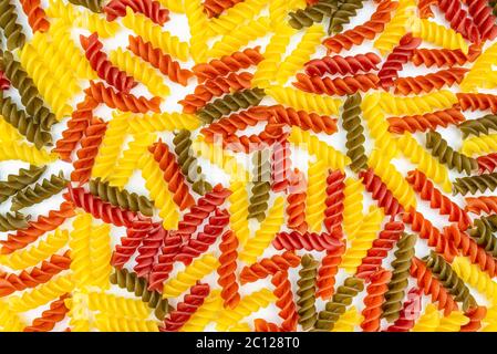 Background made of many colorful spiral macaroni lying on white background, top view, macaroni texture. Stock Photo