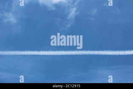 white stripe on the airplane in the blue cloudless sky. Stock Photo