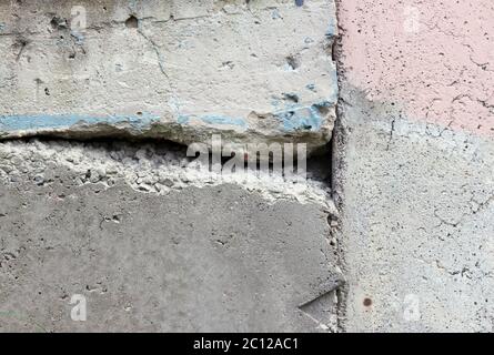 texture of a concrete wall with cracks and the remnants of a pink and blue paint. Stock Photo