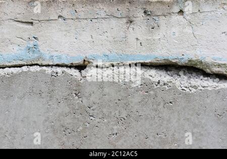 texture of a concrete wall with cracks and the remnants of a blue paint. Stock Photo