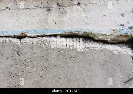 texture of a concrete wall with cracks and the remnants of a blue paint. Stock Photo