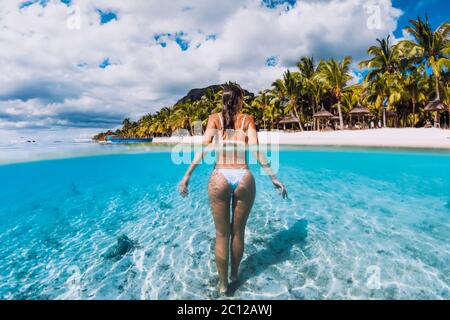 Young attractive woma posing in transparent blue ocean. Swimming in blue water at Mauritius