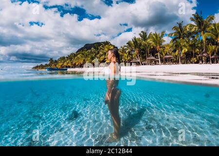 Attractive woman posing in transparent blue ocean. Swimming in blue water at Mauritius