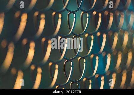 Golden hour metal wire fence pattern Stock Photo