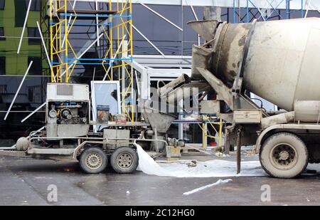 concrete pump and  mixer to work together  pouring cement floors in the shopping center for repair. Stock Photo