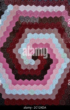 Close up of a colourful spiral traditional hexagonal knitted crochet pattern. Stock Photo