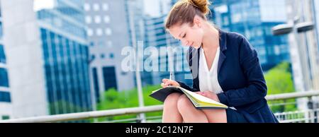 dynamic young executive taking notes on her agenda Stock Photo