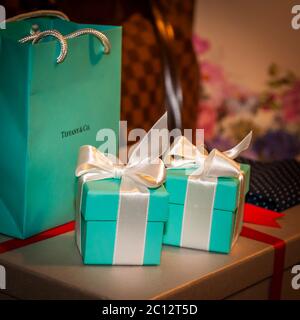 Two turquoise Tiffany & Co. gift boxes with white satin bows sit ready. The matching carrier bag stands beside them. The gifts are part of the preparations for a British wedding in South Cambridgeshire, England. Stock Photo