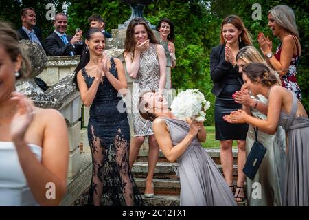 Who will catch the bridal bouquet and be the next to get hitched? Throwing of the bridal bouquet after Wedding in South Cambridgeshire, England Stock Photo