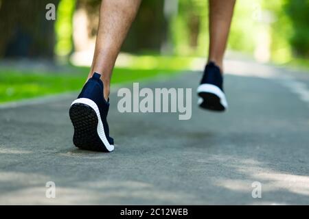 Cropped view of marathon runner working out at park in morning, close up of legs Stock Photo
