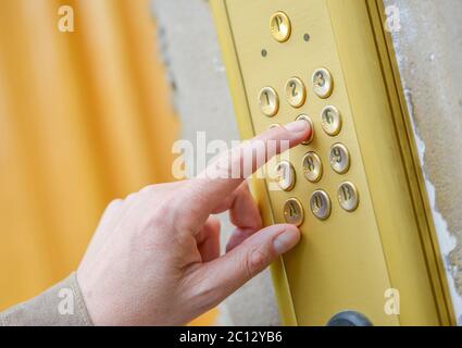 Close-up of person using building intercom Stock Photo