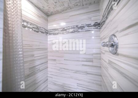 Shower room of a bathroom with glossy black and gray tiles on wall and ceiling Stock Photo