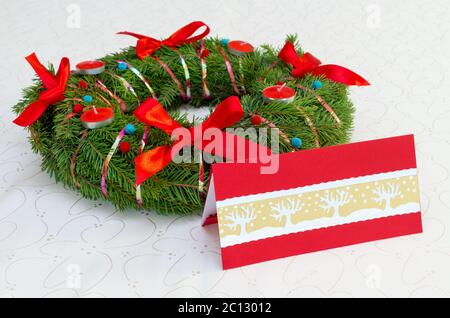 Classical Christmas wreath with red candles and card on the tablecloth Stock Photo