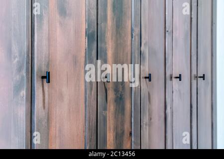 Close up of dark brown wooden doors of a cabinet with black handles Stock Photo