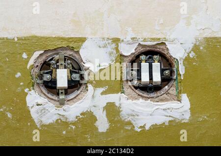Two old electric switches mounted in the wall. The covers of switches is open. Stock Photo