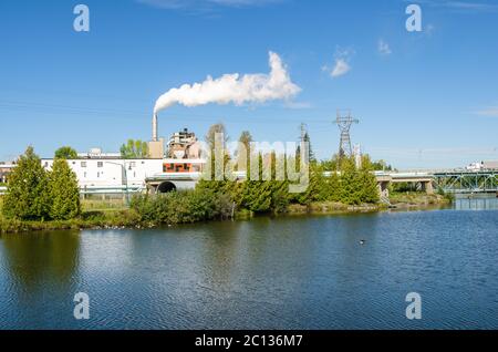Manufacturing plant along a river on a clear early autumn day Stock Photo