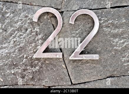 22, number twenty-two, metal digits on stone surface. Stock Photo