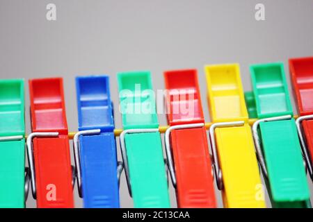colored plastic clothespins hanging on the rope. Stock Photo