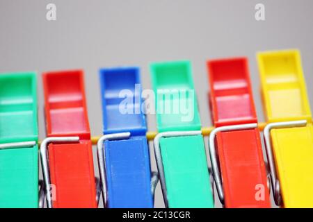 colored plastic clothespins hanging on the rope. Stock Photo