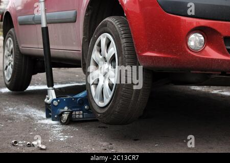 installation of passenger car wheel and replacement on winter tire. Stock Photo