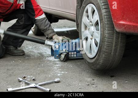 installation of passenger car wheel and replacement on winter tire. Stock Photo