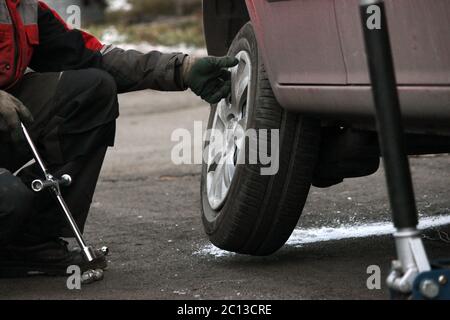 installation of passenger car wheel and replacement on winter tire. Stock Photo