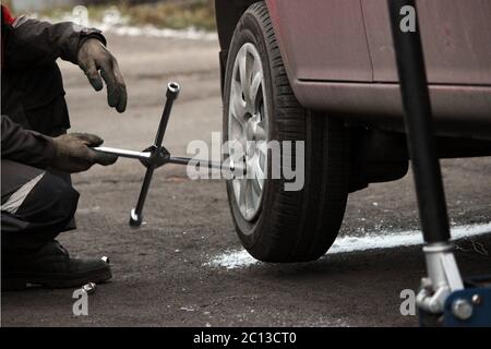 installation of passenger car wheel and replacement on winter tire. Stock Photo