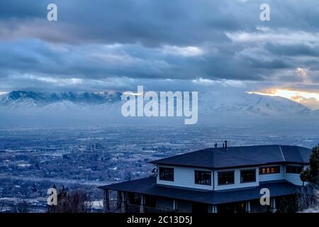 Downtown Salt Lake City with snowy mountain and gloomy cloudy sky view in winter Stock Photo