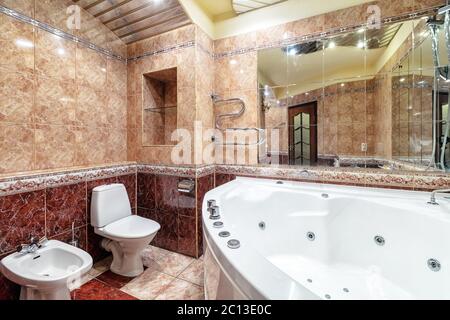 Spacious new empty jacuzzi bath tube in bathroom interior with modern tile Stock Photo