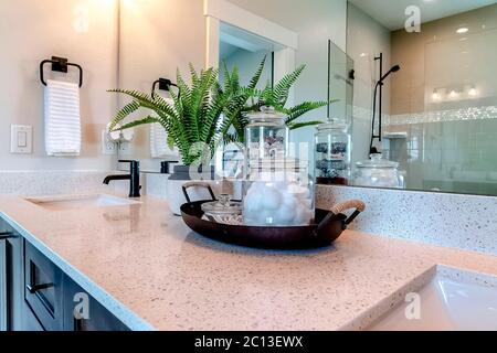 Two sinks with black faucet on white countertop over vanity wooden cabinets Stock Photo