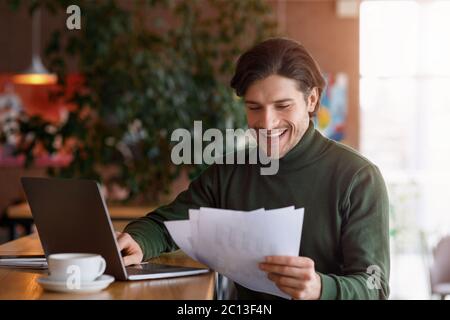 Happy man entrepreneur working with documents at cafe Stock Photo