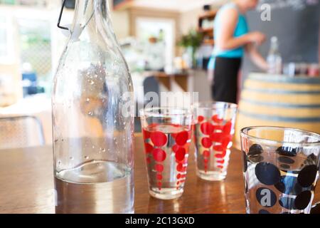 glasses and bottle with water on table Stock Photo
