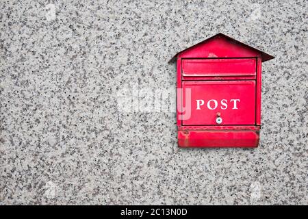 Red post box on wall Stock Photo