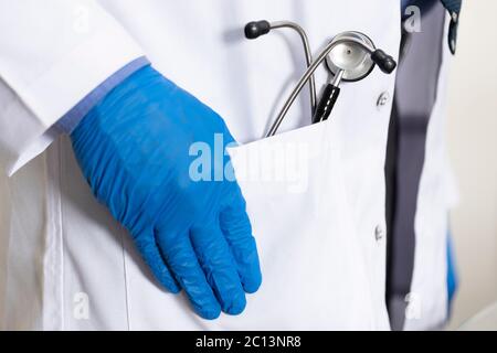 close up of Stethoscope in a doctors coat, blue gloves. Stethescope in a pocket Stock Photo