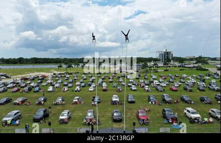 June 13, 2020 - Sarasota, Florida, United States - In this aerial view from a drone, Erendira Wallenda (left) and Alec Bryant perform on the sway poles at Nik Wallenda's Daredevil Rally, billed as the world's first drive-in stunt show, on June 13, 2020 in Sarasota, Florida. The show, which runs on select dates through June 21, features internationally known daredevil performers and is designed to be a safe event during the coronavirus pandemic, with the separation of spectator's vehicles according to social distancing guidelines. (Paul Hennessy/Alamy) Stock Photo
