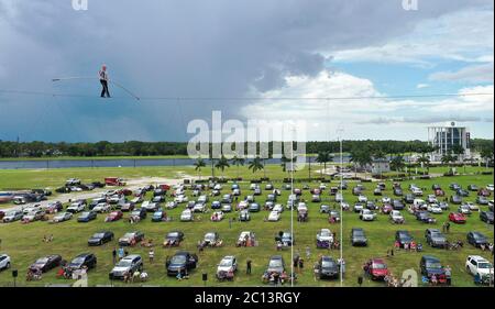 June 13, 2020 - Sarasota, Florida, United States - In this aerial view from a drone, high wire artist Nik Wallenda performs at Nik Wallenda's Daredevil Rally, billed as the world's first drive-in stunt show, on June 13, 2020 in Sarasota, Florida. The show, which runs on select dates through June 21, features internationally known daredevil performers and is designed to be a safe event during the coronavirus pandemic, with the separation of spectator's vehicles according to social distancing guidelines. (Paul Hennessy/Alamy) Stock Photo