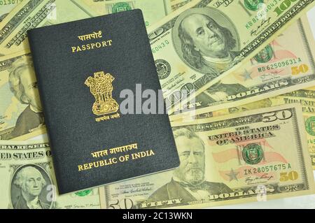 Indian passport on US currency bills. Passport is a travel document issued by country's government to the citizens and US official currency dollar.