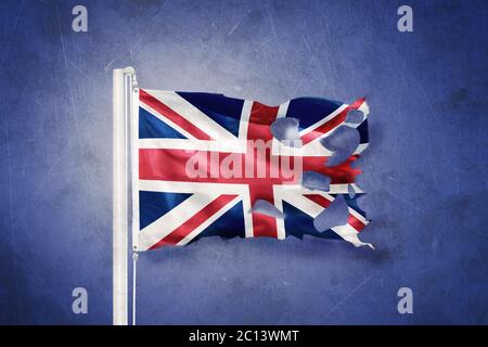 Torn flag of United Kingdom flying against grunge background Stock Photo