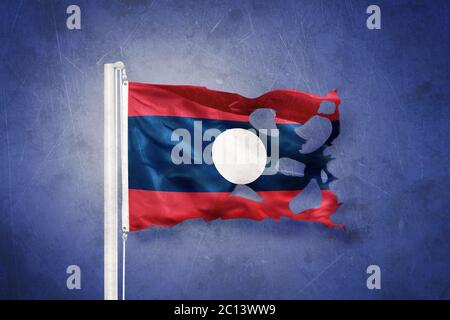 Torn flag of Laos flying against grunge background Stock Photo