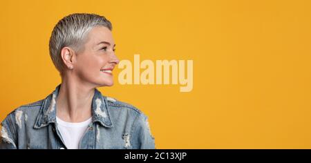 Nice Promo. Smiling Mature Lady Looking With Interest At Copy Space Stock Photo
