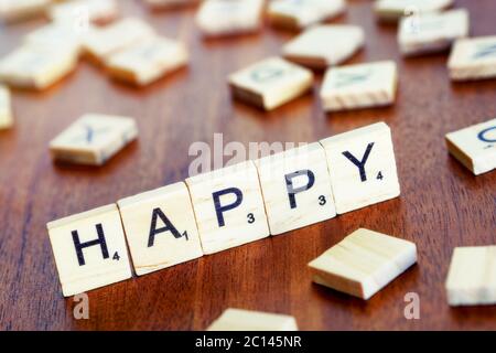 happy word on block concept, letters placed on a desk in precious wood Stock Photo