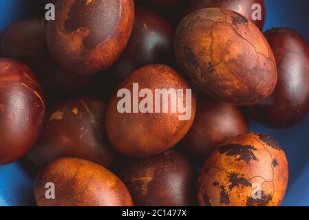 Easter eggs in the blue ceramic bowl. Painted brown with spots and cracks Stock Photo