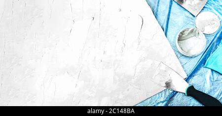 plastered Board, metal spatula, jar of cement, brush for molar paint, blue rag and a blue celophane floor covering. self-repair and home decor, buildi Stock Photo