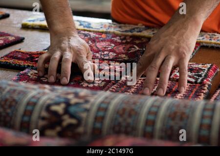 traditional hand sewing fixing old vintage antique persian carpet up close Stock Photo