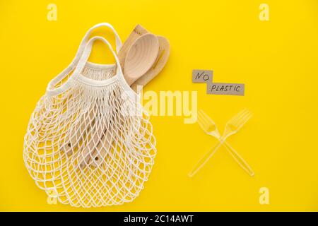 Plastic free and zero waste lifestyle eco store concept. Top view, flat lay on green background of mesh bag and spoons. Stock Photo