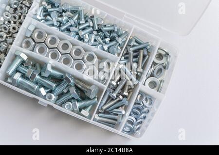 Many steel nuts and bolts in a white plastic box Stock Photo